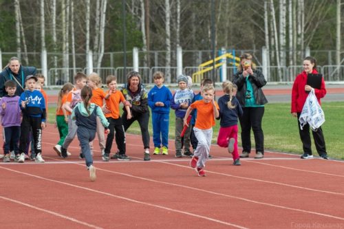 школьники бегут эстафету на стадионе